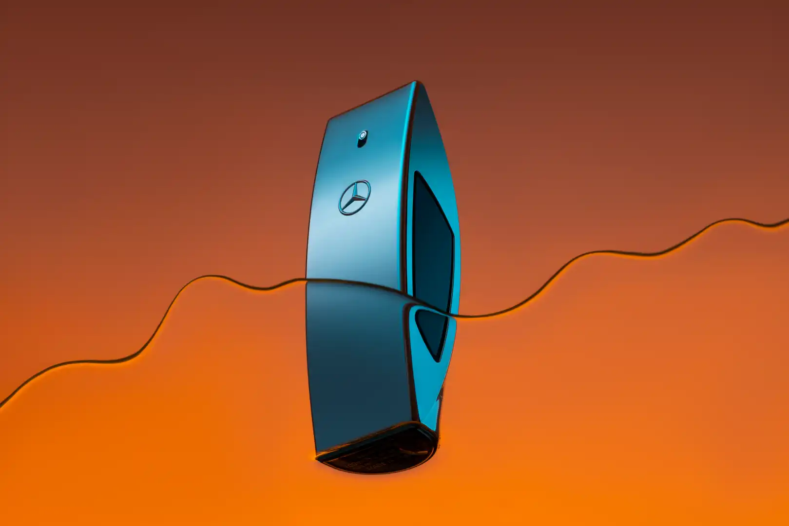 Blue Mercedes-Benz key fob partially submerged in reflective orange liquid with wavy surface.