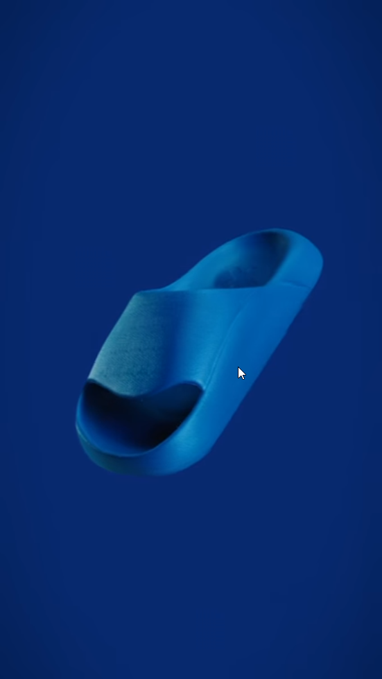 Single blue slide sandal with a thick strap, floating against a dark blue background.